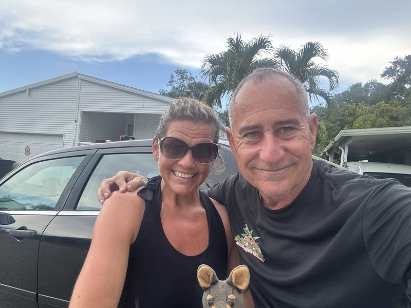 Two people in front of a black car highlighting effective junk car removal in Broward County