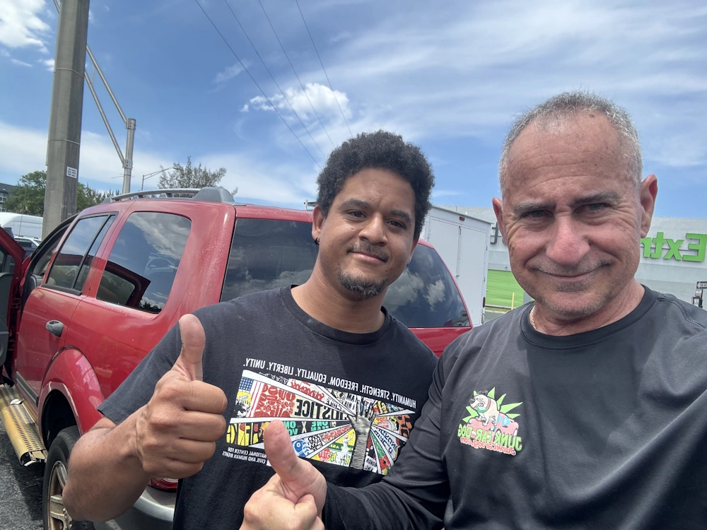 Happy customer giving two thumbs up after a cash for junk cars in South Florida reviews experience with Junk Car Dog"
