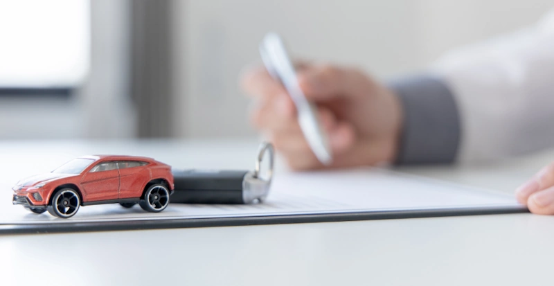 a close-up of a toy car, keys and car documents