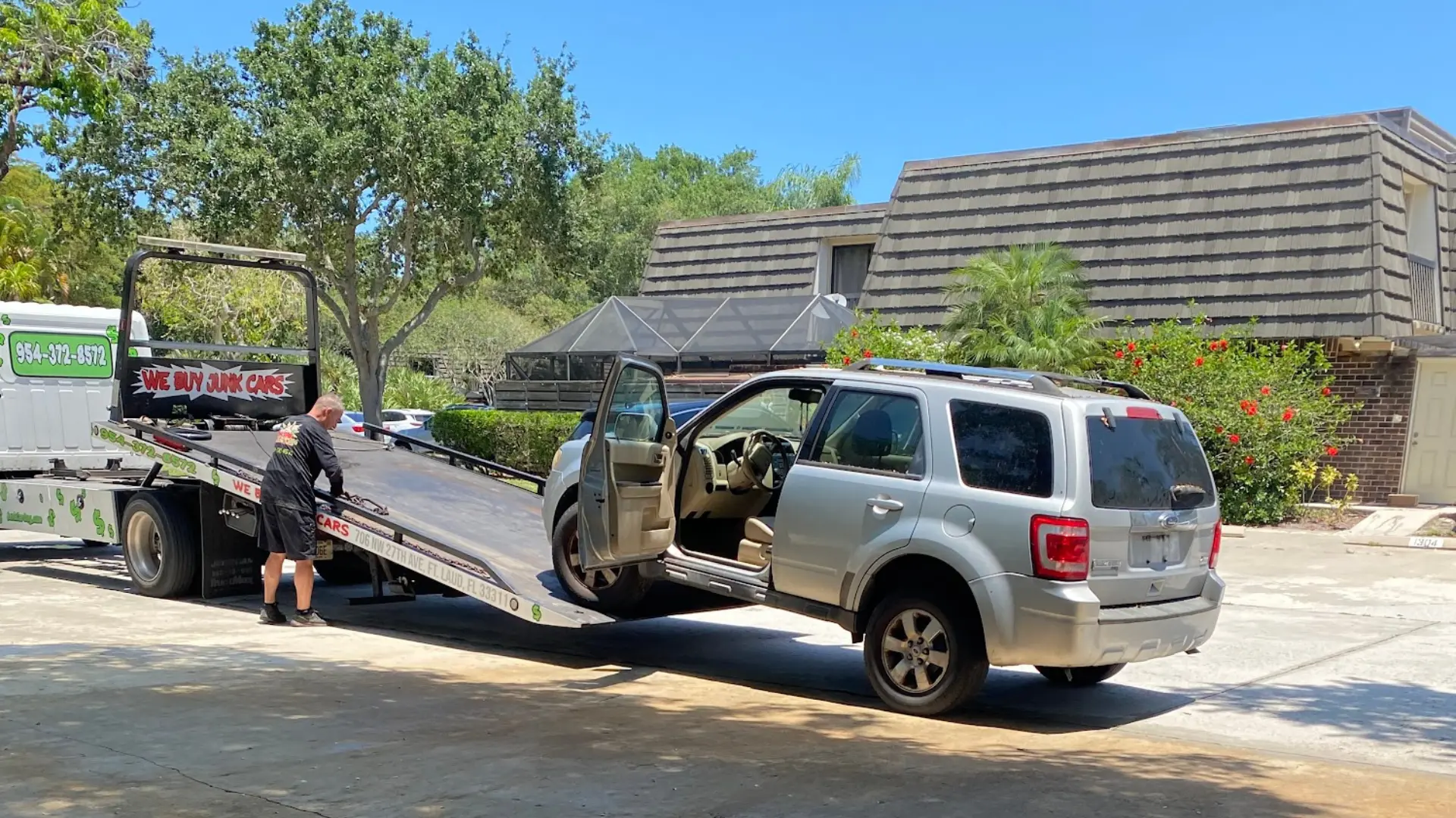 Junk Ford Escape for cash in Palm Beach Gardens being loaded onto a tow truck