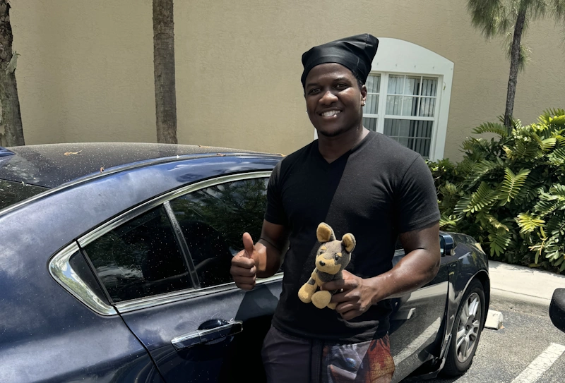 Person beside a car giving a thumbs-up for Junk Car Buyer in Coral Springs FL