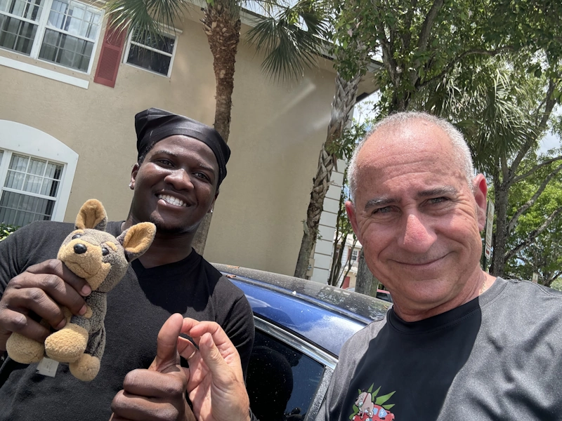 Two smiling people with a stuffed animal, symbolizing positive experiences with a Hillsboro Beach junk car buyer.