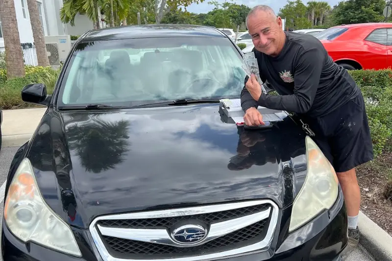 Customer receiving cash for an old Subaru Legacy junk car in Miramar FL